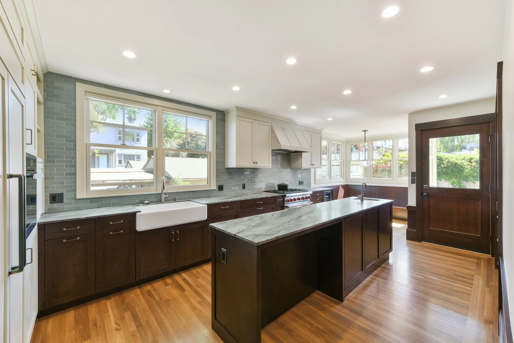 Kitchen with hardwood floor and farmhouse sink and quartz countertop